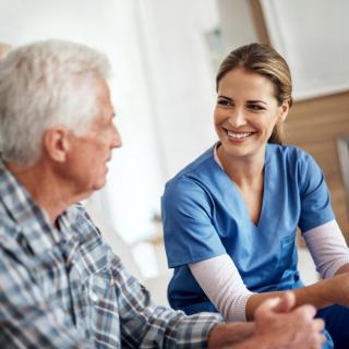 A nurse engaging with an elderly patient in a healthcare setting.
