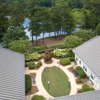 Aerial view of a landscaped courtyard with surrounding buildings and a nearby lake.