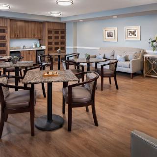 A cozy dining area with wooden tables and chairs, set in a room with warm wood flooring and comfortable decor.