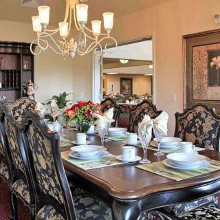Elegant dining room with a beautifully set table and chandelier lighting.