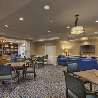 A comfortable lounge area with tables, chairs, and a library section.