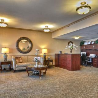A spacious and elegantly designed lobby featuring comfortable seating, decorative mirrors, and ambient lighting.