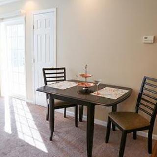 A minimalist dining area with a small table and two chairs.