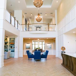 Spacious modern living room with a dining area and elegant chandeliers.