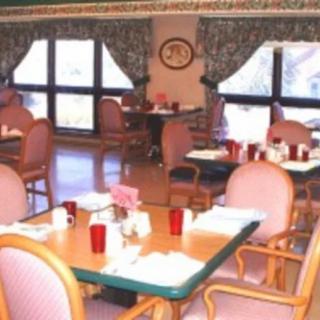 A cozy and well-decorated dining room with tables and chairs set for guests.