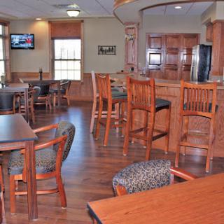 A cozy dining area featuring wooden furniture and a bar counter.