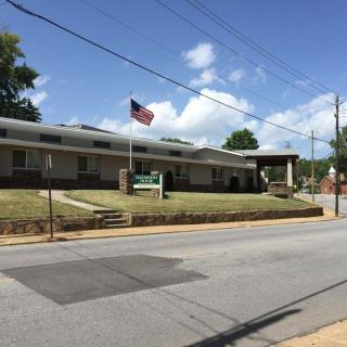 A view of a single-story building with an American flag on a clear, sunny day.