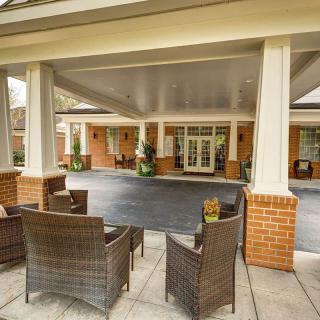 Outdoor seating area at the entrance of a building with columns.