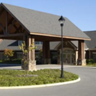 A building entrance with a covered driveway and landscaped surroundings.