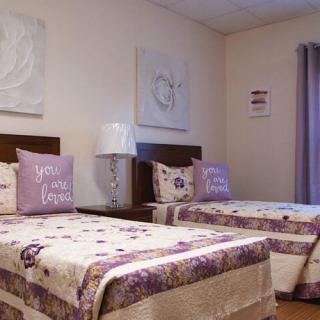 Cozy bedroom with twin beds featuring decorative pillows and subtle wall art.