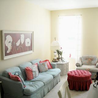 A cozy living room featuring a light-colored sofa adorned with decorative cushions, an elegant coffee table, and artwork enhancing the decor.
