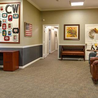 A cozy waiting room with seating and artwork on the walls.