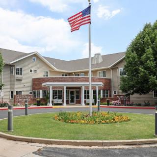 A large building with an American flag flying in front, surrounded by well-maintained landscaping and trees.
