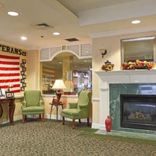 A cozy lobby with a fireplace, seating area, and an American flag on display.