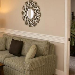 A cozy living room with a patterned sofa, decorative mirror, and cushions.