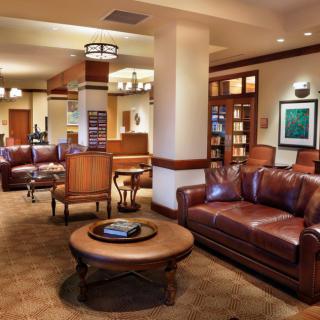 A cozy lobby area with leather sofas, elegant lighting, and warm-toned furnishings.
