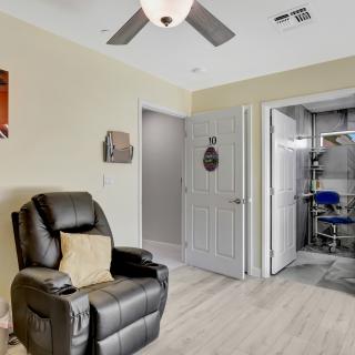 A cozy living room with a black recliner and ceiling fan, featuring modern decor.