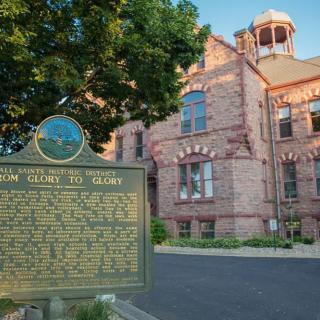 A historic building with a detailed historical marker in the foreground.