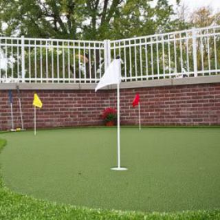 A mini golf putting green with colorful flags set up outdoors.