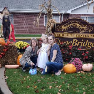 A family gathering during the autumn season, surrounded by festive decorations and pumpkins.