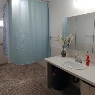 A clean and organized bathroom with a shower, sink, and mirror.