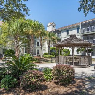 A beautiful apartment complex with a well-maintained gazebo and lush landscaping.