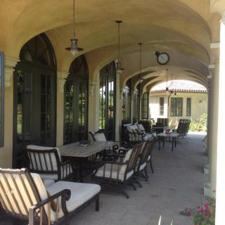 A spacious patio with comfortable outdoor seating and arched architectural design.