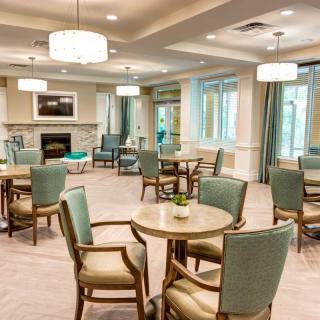 A cozy seating area with tables and chairs, illuminated by elegant lighting fixtures.