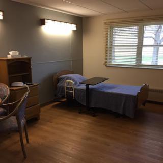 A simple and clean hospital patient room with two beds and a window.
