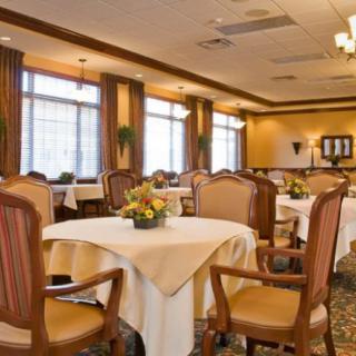 A well-lit restaurant dining area with neatly arranged tables and chairs.