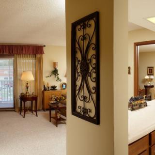A cozy living room and adjacent bedroom with tasteful decor and furniture.