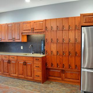 A beautifully designed modern kitchen featuring wooden cabinets, a sleek sink, and a stainless steel refrigerator.