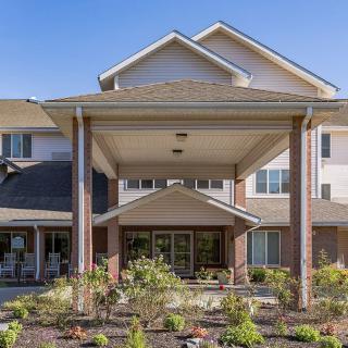 A residential building with a landscaped entrance and covered entryway.