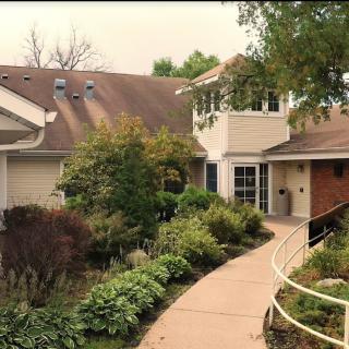 A cozy house with a lush garden and winding pathway.