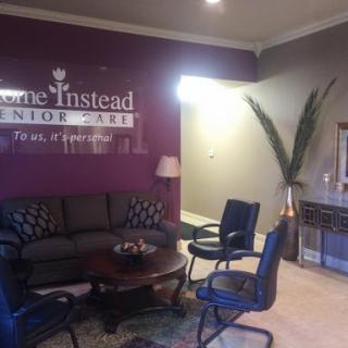 A cozy waiting area with comfortable seating and a calming purple accent wall.