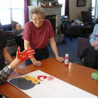 A group of people engage in a collaborative art project indoors.