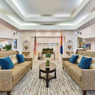 A modern living room with sofas, a central table, and a fireplace.