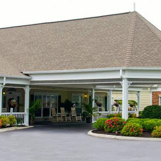 A building entrance with a covered driveway and well-maintained landscaping.