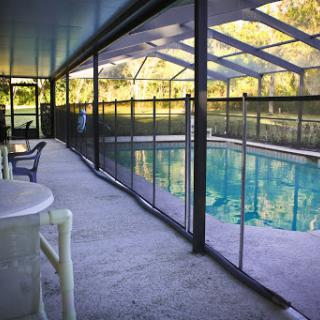 A serene indoor swimming pool area, surrounded by a screened enclosure, perfect for relaxation and enjoyment.