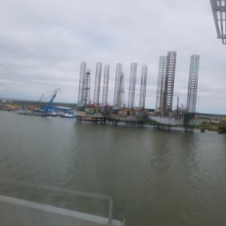 A view of oil rigs and construction equipment along the water.