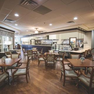 A cozy cafe interior with wooden floors and neatly arranged tables and chairs.