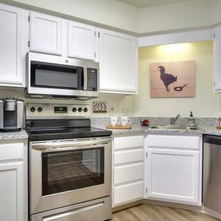 A modern kitchen with stainless steel appliances and white cabinets.