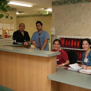 A group of healthcare workers behind a reception desk in a medical facility.