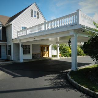 A residential building with an elevated porch and a driveway.