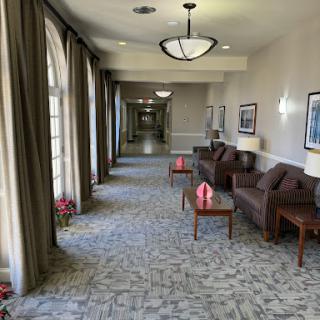A well-lit hallway featuring comfortable seating and decorative elements.