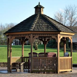 A beautifully crafted wooden gazebo situated in a green park, perfect for relaxation and gatherings.