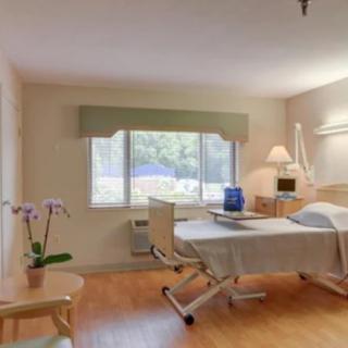 A hospital room with a bed, window, and basic amenities.