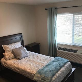 A cozy bedroom with a single bed and a window view.