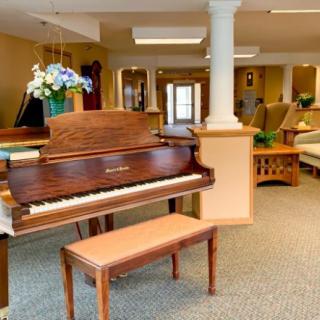 A cozy living room with a piano and comfortable seating.