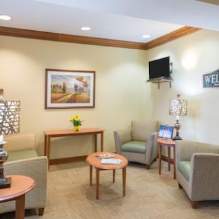 A cozy waiting area featuring soft seating, elegant decor, and warm lighting.
